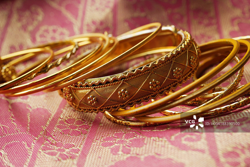 粉色纱丽布上的金色印度手镯图片素材