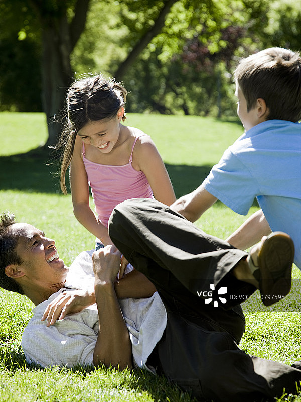 爸爸和他的两个孩子在公园里图片素材