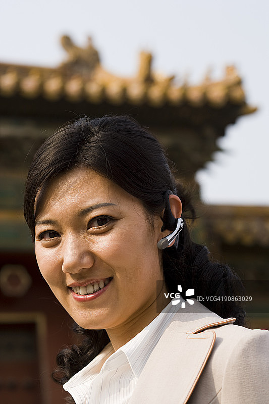 女商人戴着耳机在户外微笑图片素材
