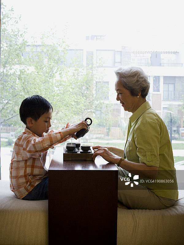 奶奶和孙子围坐在一起喝茶图片素材