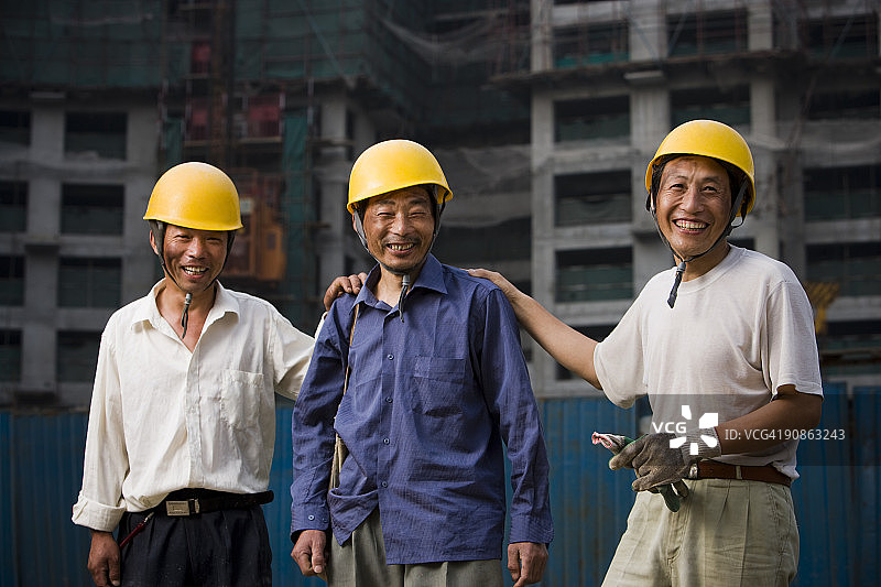 三名男建筑工人戴着头盔在户外微笑图片素材