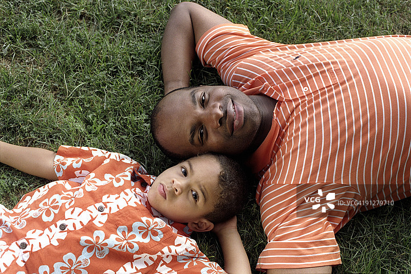 父亲和儿子躺在草地上图片素材