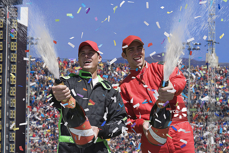 获胜的赛车手在喷洒香槟。图片素材