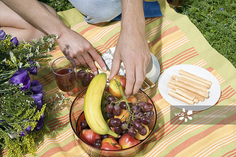 一对夫妇的特写野餐从碗里拿水果图片素材