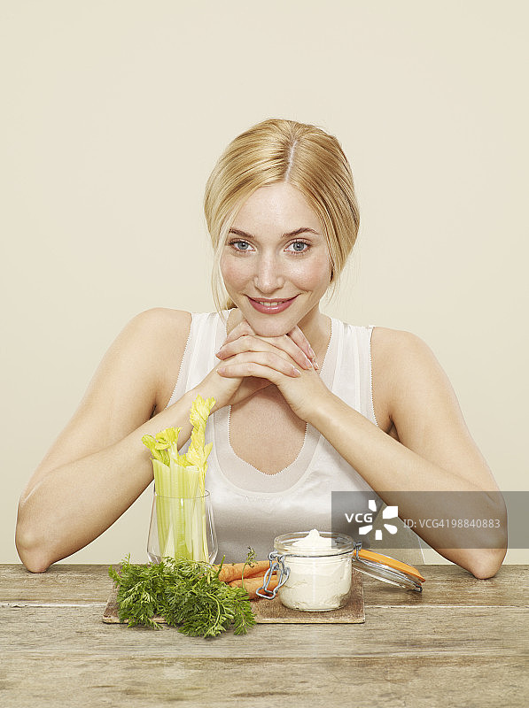 女性面前有芹菜、胡萝卜和腐殖质图片素材