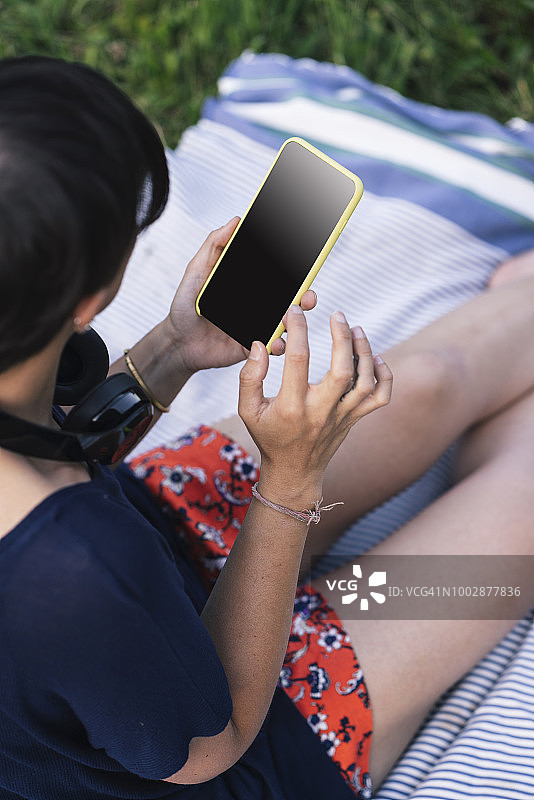 一名年轻的成年女子在公园里使用手机图片素材