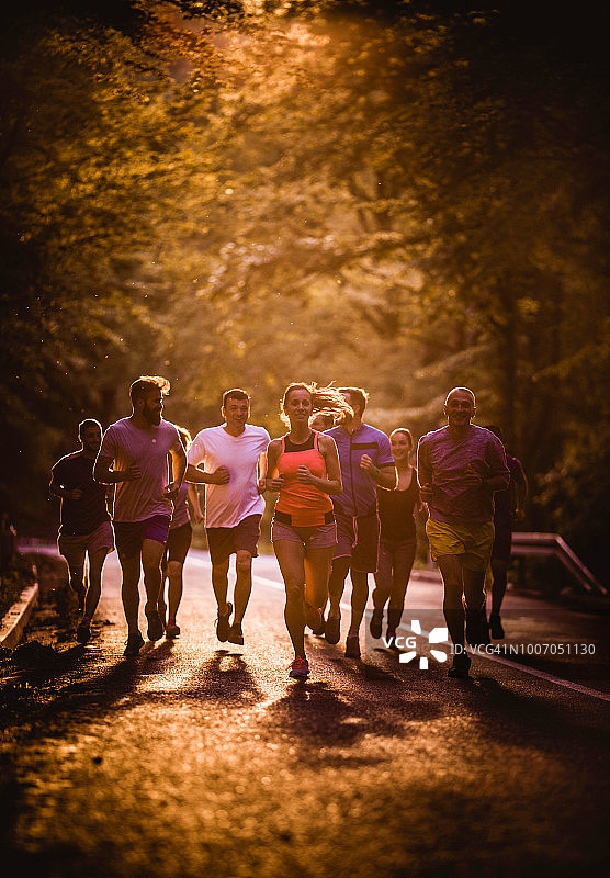 日落时分参加马拉松比赛的一组运动员。图片素材