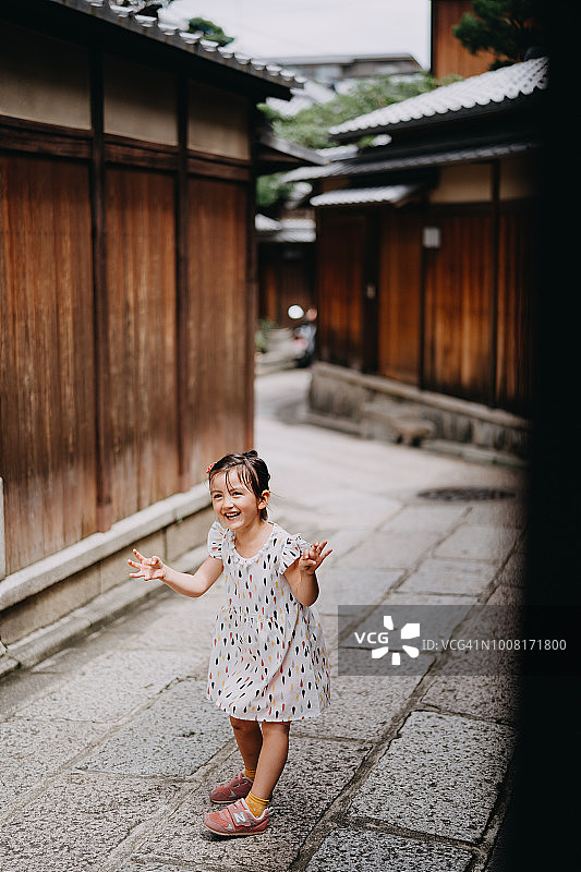 可爱的小女孩在京都的老街做鬼脸图片素材