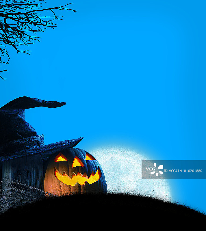 杰克O灯和女巫的帽子坐在小山上，在升起的月亮前图片素材