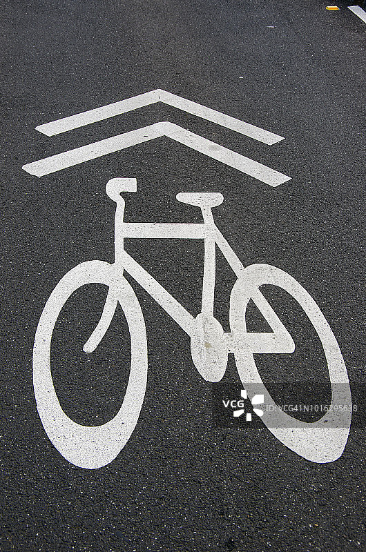 印在柏油路上的自行车标志和方向箭头图片素材