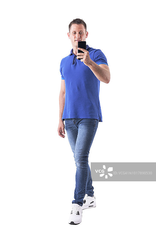 快乐的年轻成年人休闲男人在蓝色polo衫与智能手机自拍图片素材