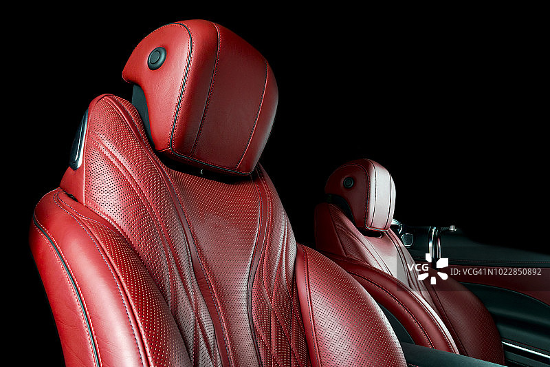 汽车内部。汽车的内部。舒适的真皮红色座椅。红色的穿孔皮革。汽车内饰的细节。汽车详细图片素材