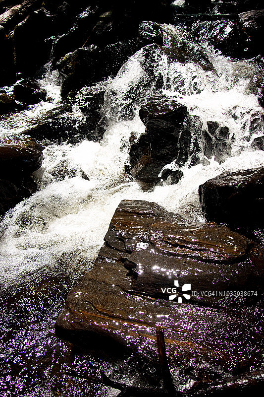 白水在岩石上流动的特写图片素材