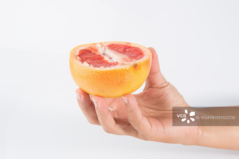 手握橘子卡拉卡拉水果在白色的背景孤立图片素材