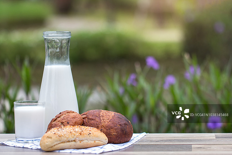 牛奶和面包在木桌上，自然的背景图片素材