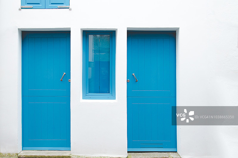 蓝色的门和窗户靠着白色的墙图片素材