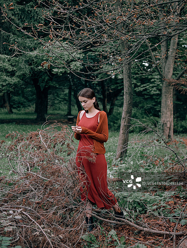 森林里一个穿着红裙子的女人的画像图片素材