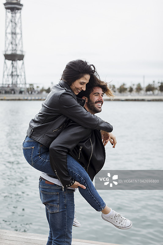 西班牙，巴塞罗那，幸福的年轻夫妇在海边玩图片素材