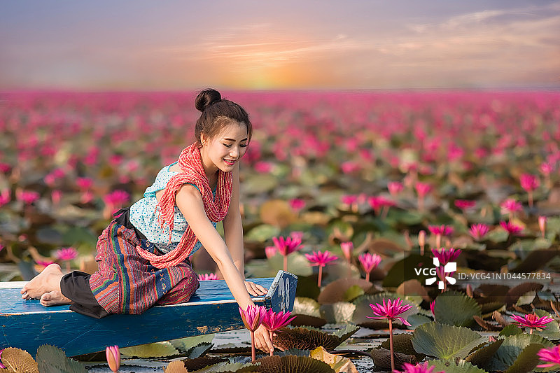 女人放松与美丽的莲花花田在红莲海，泰国。图片素材