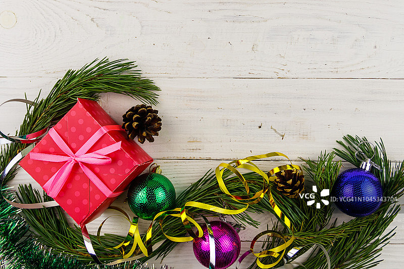 用冷杉树枝、礼物盒和圣诞装饰品组成的圣诞作文在白色的木制桌子上。俯视图，复制空间图片素材