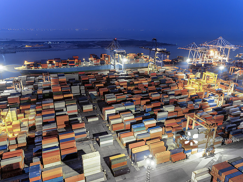 鸟瞰泰国码头上集装箱箱和集装箱船的夜景。图片素材