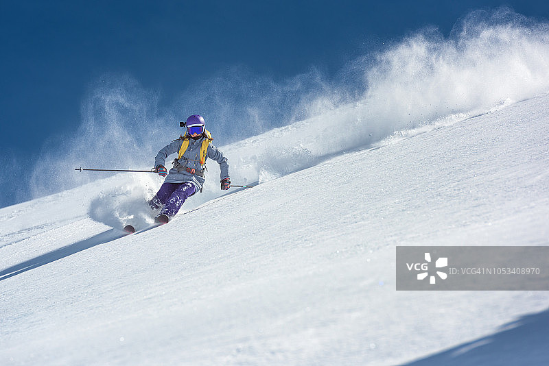 女滑雪者在新鲜的粉状雪上雕刻图片素材