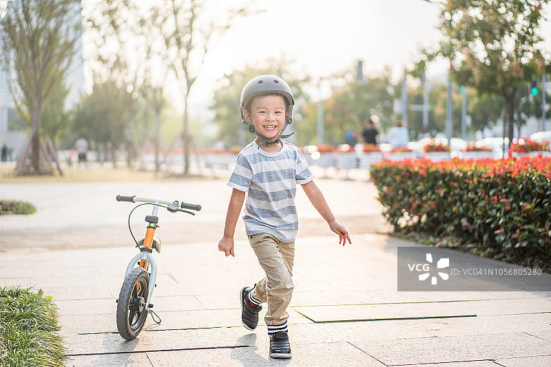 一个小男孩在滨江徐汇玩自行车，上海图片素材