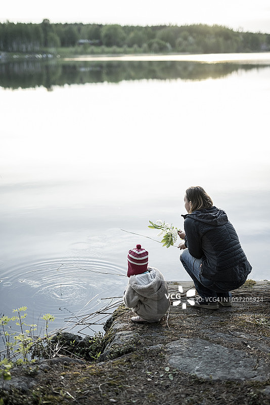 芬兰，库奥皮奥，母女蹲在湖边图片素材