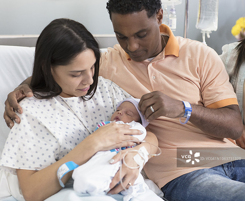 一对夫妇在医院欣赏他们刚出生的宝宝图片素材