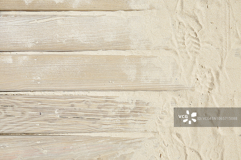 高角度的木板路与沙子和脚印图片素材