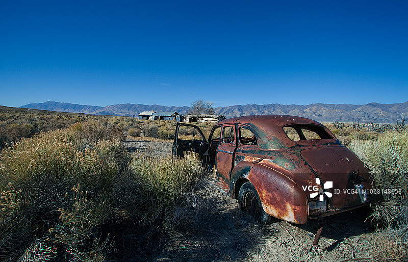 大镜头老生锈的1930年的汽车被遗弃在牧场沙漠景观。图片素材