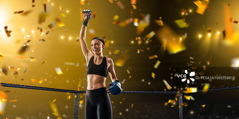 女子综合格斗选手在职业拳击台上为胜利而欢呼图片素材