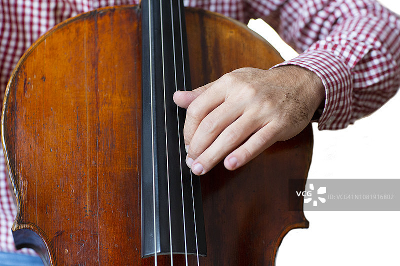 大提琴手演奏大提琴手靠近管弦乐器孤立的图像在白色的背景。图片素材