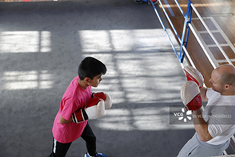 一个年轻的男拳击手在拳击台上奋力拼搏的镜头图片素材