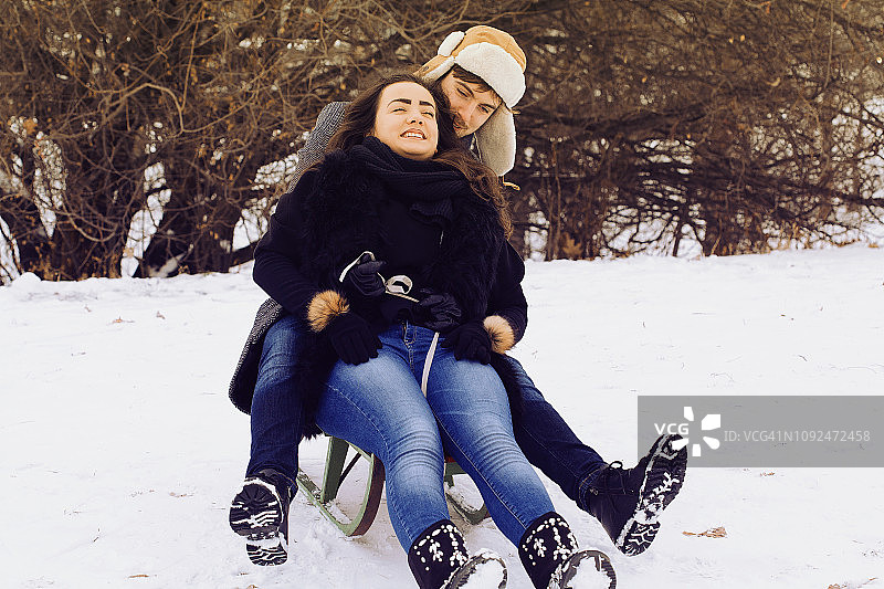 一对年轻的夫妇在冬日里拉雪橇图片素材