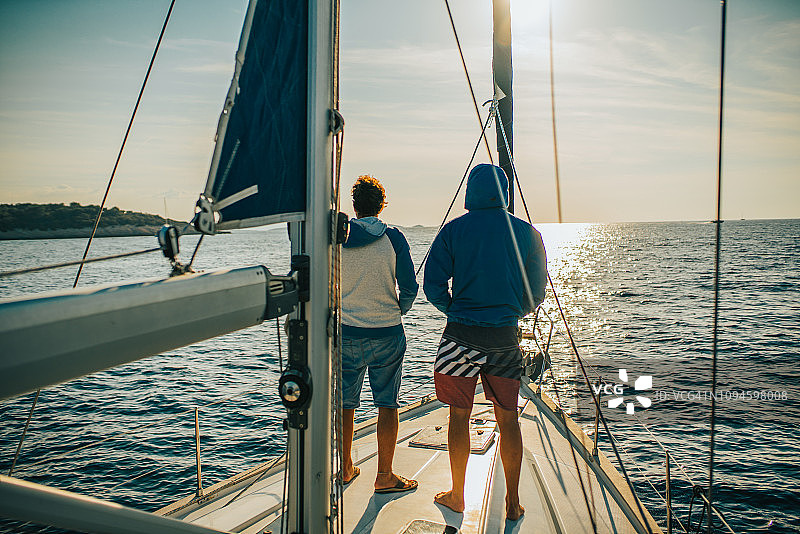 克罗地亚，两名游客站在一艘帆船上图片素材