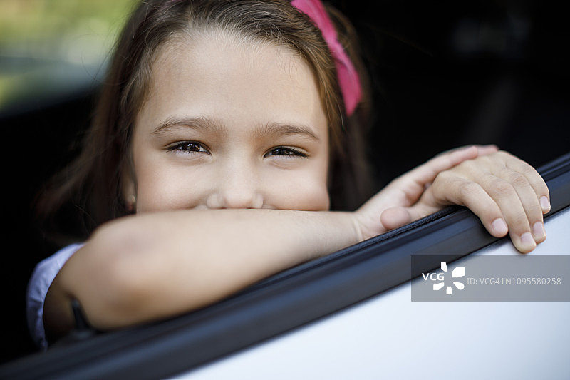 快乐微笑的小孩坐在车里的肖像图片素材