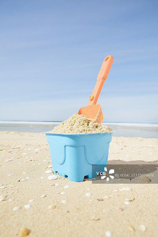 沙桶和铲子放在海滩上图片素材