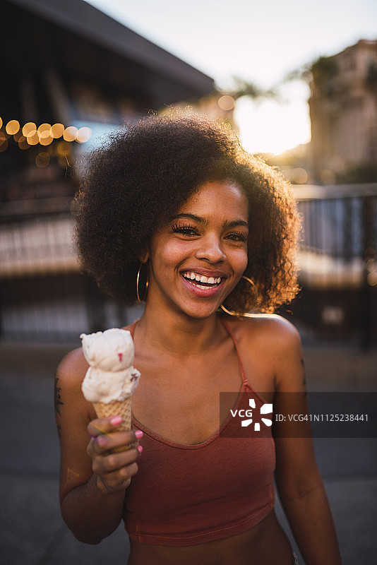 美国，内华达州，拉斯维加斯，快乐的年轻女子在城市吃冰淇淋的肖像图片素材