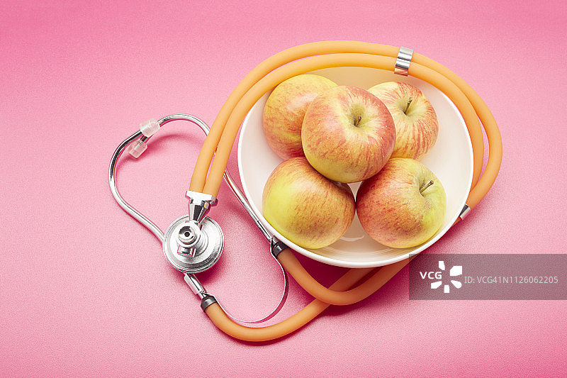 高角度观察碗，苹果和听诊器图片素材