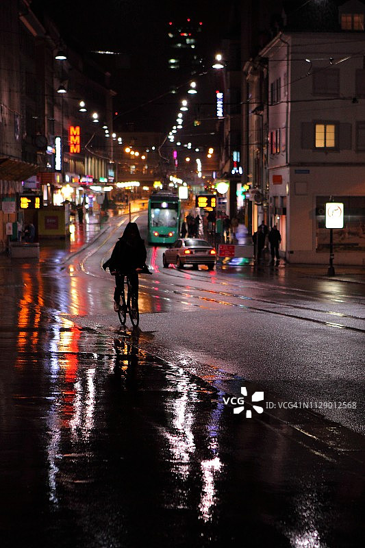 雨中夜晚骑自行车的人的剪影图片素材
