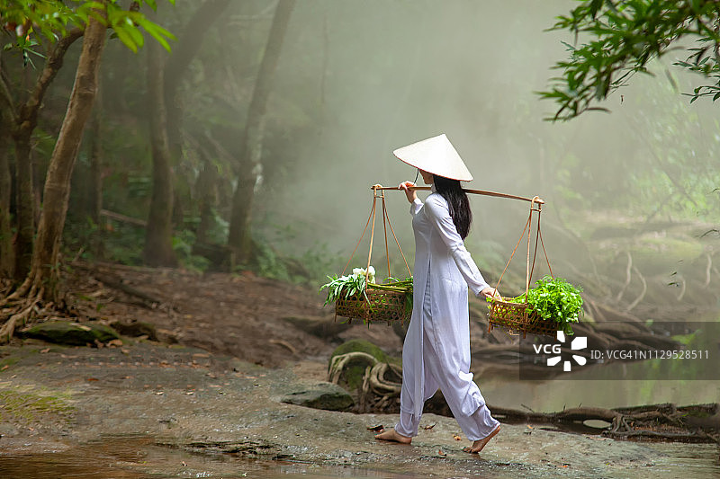 一个美丽的越南女人穿着白色的裙子。图片素材