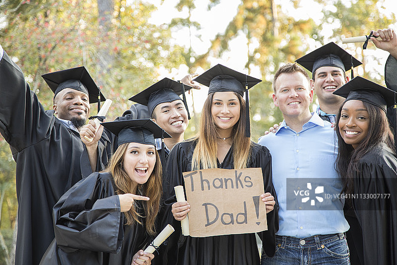 毕业典礼后，大学生们举着“谢谢爸爸”的牌子。图片素材