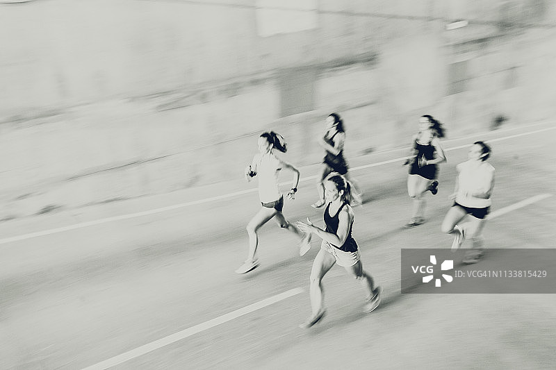 一群在街上奔跑的年轻女孩，模糊的动作图片素材