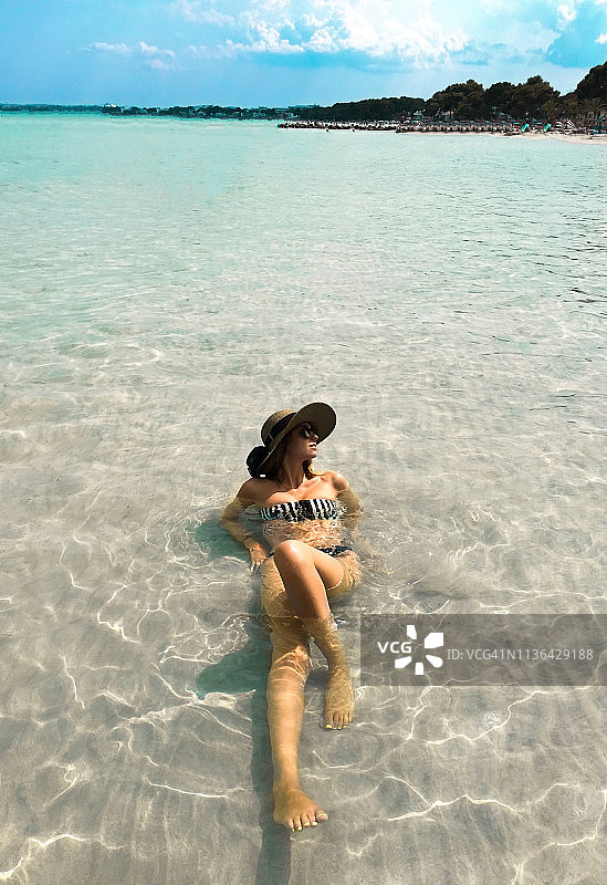 年轻女子在热带国家的海滩上享受时光图片素材