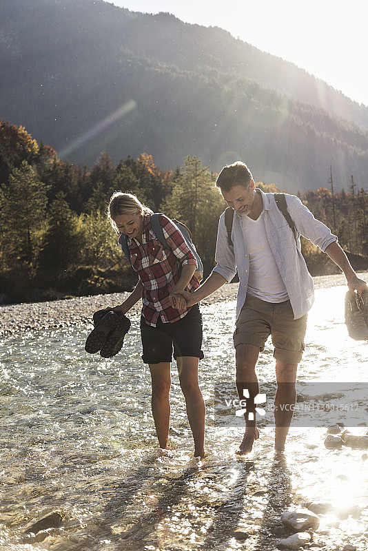 奥地利，阿尔卑斯山，夫妇徒步旅行涉水小溪图片素材