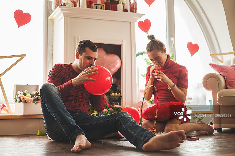 相爱的情侣在情人节吹气球图片素材