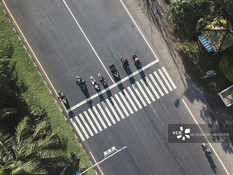 印度尼西亚，巴厘岛，萨努尔，摩托车在马路上等待斑马线的鸟瞰图图片素材