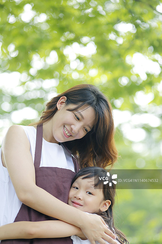 母亲和女儿在公园里拥抱图片素材