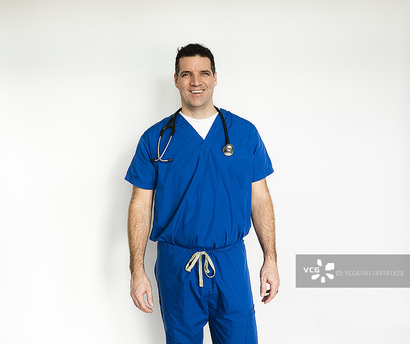 穿着外科手术服的医生站在白色的背景下。图片素材